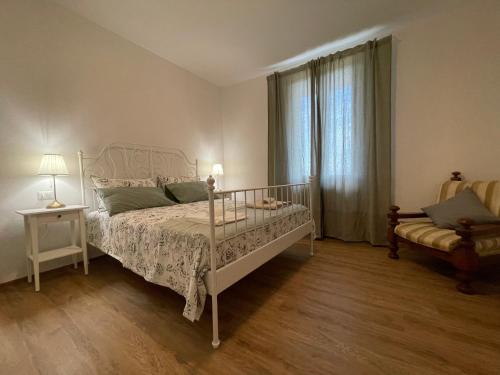 een slaapkamer met een wit bed en een raam bij Agriturismo Nonno Dante - Casa Leccino in Castiglion Fibocchi