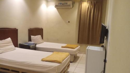 a hospital room with two beds and a television at سلسبيل للغرف المفروشة in Al Khobar