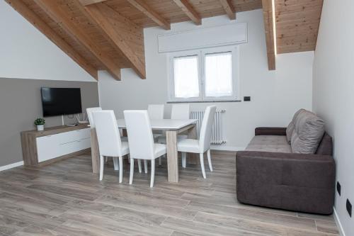 - un salon avec une table, des chaises et un canapé dans l'établissement Affittacamere Bar Leo, à Pregnana Milanese