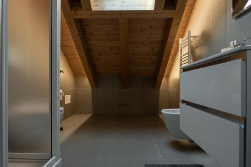 La salle de bains est pourvue d'un plafond en bois et de toilettes. dans l'établissement Affittacamere Bar Leo, à Pregnana Milanese
