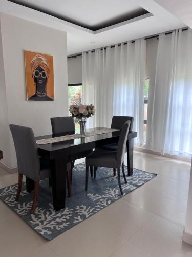 a dining room with a black table and chairs at Kaya Apartments 2 in Lusaka