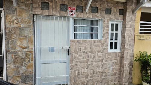 マレシアスにあるCasa Will Maresiasの白いドアと窓のある石造りの家