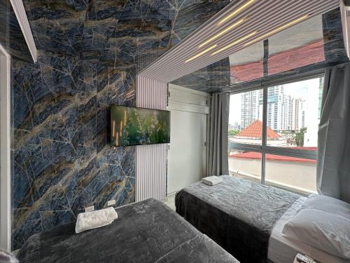 a bedroom with two beds and a tv on a wall at 7a in Panama City