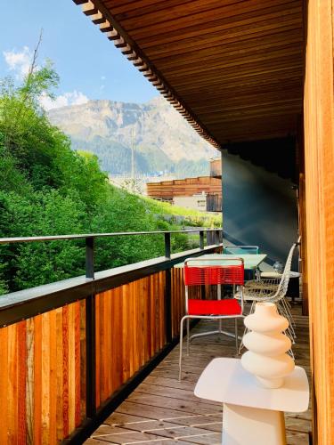 a balcony with a table and chairs and a view at Sunny Stenna Selva 3-room ski-in ski-out apartment right by the slopes & lifts in Flims