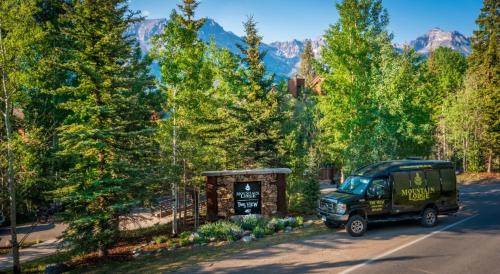 a green truck parked next to a sign on a road at Mountain Lodge Telluride in Telluride