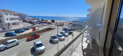 a balcony with a view of a parking lot with cars at Salema Beach Apartment in Salema