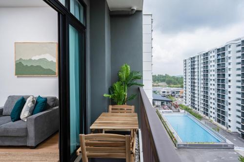 a balcony with a table and a couch and a pool at Casablanca Desaru in Desaru