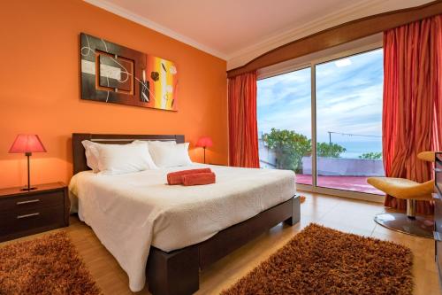 a bedroom with a large bed and a large window at Wonder House in Feteiras