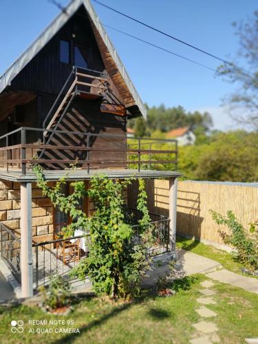 a wooden house with a staircase in a yard at Kuca za odmor Milica in Vrnjačka Banja