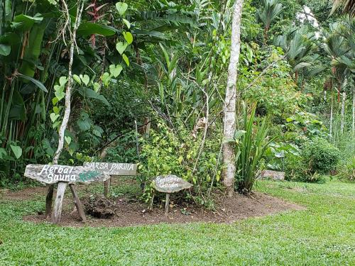 a sign sitting in the grass next to a bench at Wildlife Lodge Cahuita in Cahuita