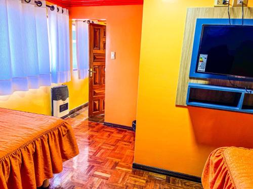 um quarto com uma cama e uma televisão de ecrã plano em HOSTAL SAN MARCOS POTOSÍ em Potosí