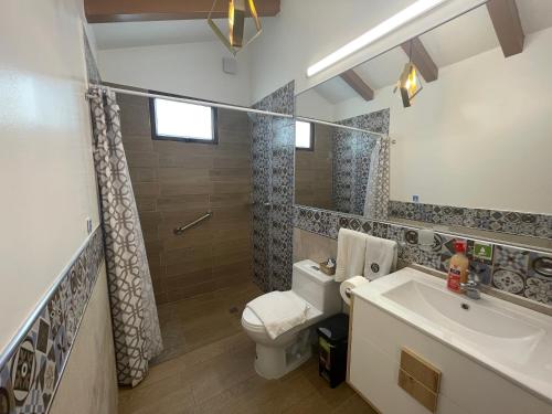 a bathroom with a toilet and a sink and a shower at Hosteria Punta Blanca in Punta Blanca