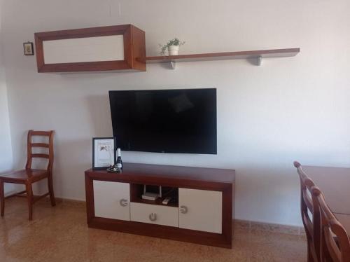 sala de estar con TV de pantalla plana en la pared en Villa Rosario en San Fulgencio