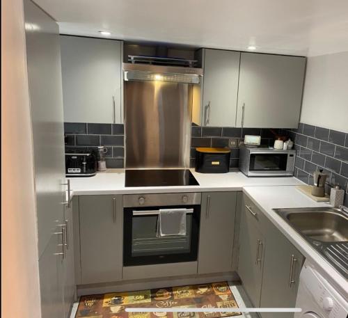 a kitchen with a sink and a stove top oven at Central Private Double Bedroom in a 2bedroom Apartment, connected via underground, overground and many bus routes in London