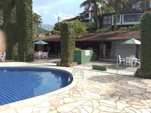 a courtyard with a swimming pool and a house at Paraíso em Angra dos Reis in Angra dos Reis