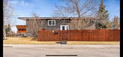 a house with a wooden fence in front of it at hunter' s new home! in Calgary