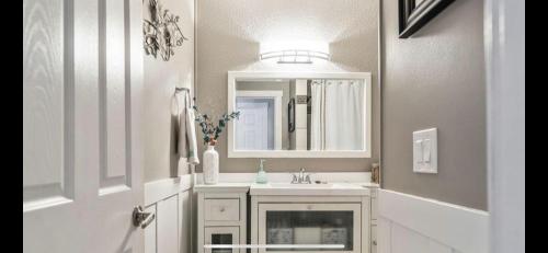 een badkamer met een witte wastafel en een spiegel bij hunter' s new home! in Calgary
