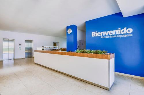 an office lobby with a blue sign on the wall at One Leon Poliforum in León