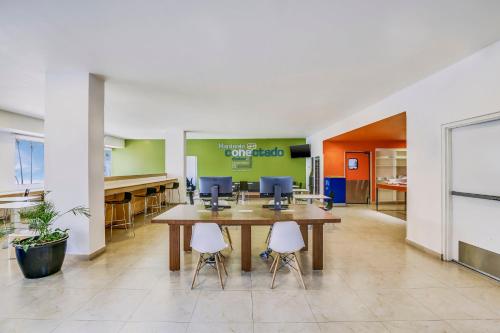 an office with a large table and two chairs at One Leon Poliforum in León