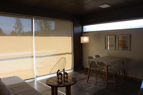 a living room with a table and a large window at Las Marias 21 in San Salvador de Jujuy