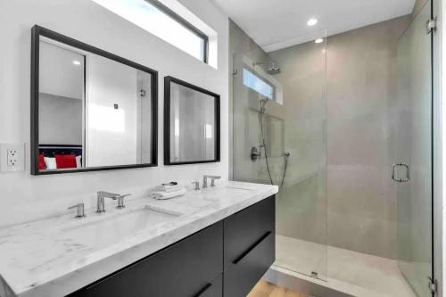 a bathroom with two sinks and a glass shower at Paradise House w Pool & Yard in Miami