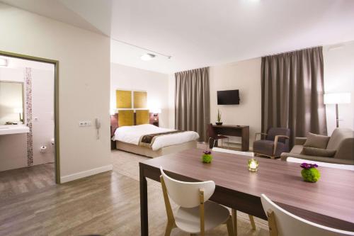 a hotel room with a bed and a table and chairs at Kyriad Chambéry Centre - Hôtel et Résidence in Chambéry