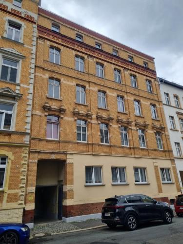 a building with a car parked in front of it at maremar - Style Apartment im Zentrum - Luxus Boxspringbett - Küche - Arbeitsplatz - Highspeed WLAN in Gera