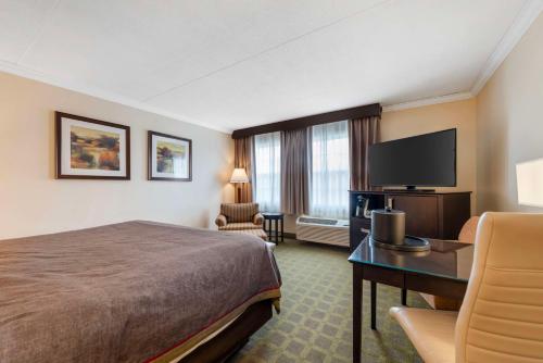 a hotel room with a bed and a flat screen tv at Best Western Plus White Bear Country Inn in White Bear Lake