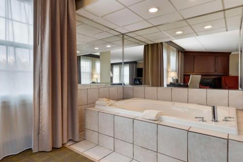a large bathroom with a tub and a large mirror at Best Western Plus White Bear Country Inn in White Bear Lake