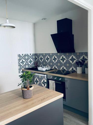 - une cuisine avec du carrelage bleu et blanc sur le mur dans l'établissement Appartement centre de Charlieu, à Charlieu