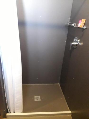 a bathroom stall with a black door with a silver handle at Onkel Inn Wagon Sleepbox Uyuni in Uyuni
