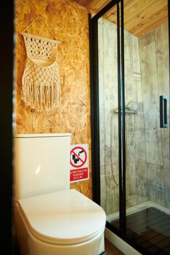 a bathroom with a toilet and a no smoking sign at cuchibus in Madrid