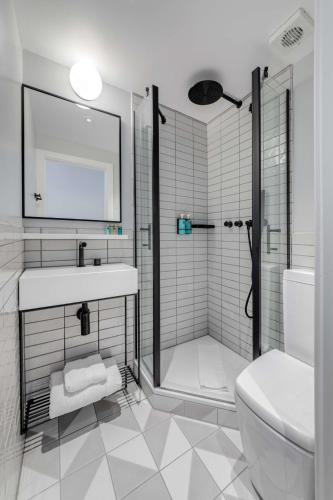 a bathroom with a shower and a sink and a toilet at Mornington Hotel London Kensington, BW Premier Collection in London