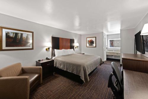 Pokój hotelowy z łóżkiem i krzesłem w obiekcie Best Western Executive Inn w mieście Grove City