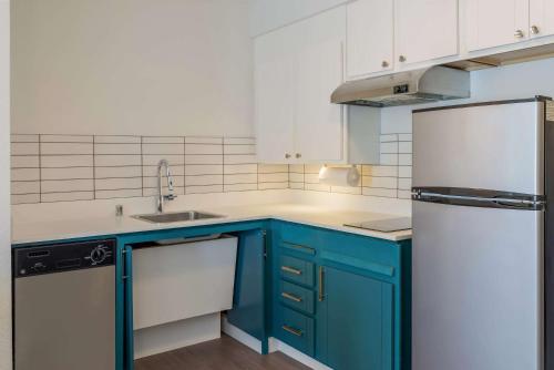a kitchen with blue cabinets and a white refrigerator at Sonesta ES Suites Denver South Park Meadows in Lone Tree