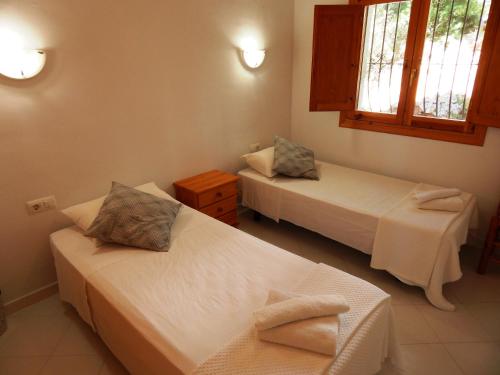 Orba的住宿－Villa Paloma，带两张床和两个窗户的房间