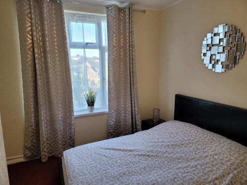 1 dormitorio con cama y ventana en Bright And Homely 1 bedroom flat, en Reading