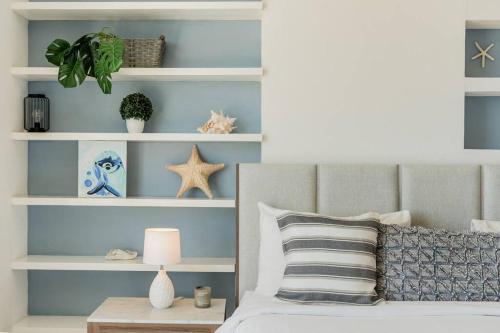 a bedroom with a bed with blue walls and white shelves at ☆BLUE NEST- Beachfront apartment by CASA PARAISO☆ in Cancún