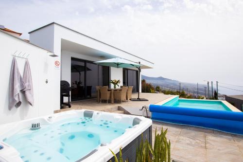 a hot tub on the patio of a house at Villa Sundowner in Prazeres