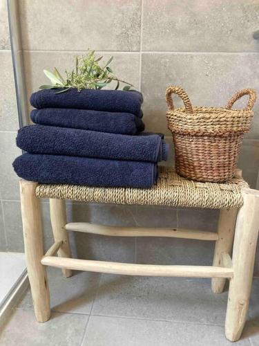 une pile de serviettes sur un tabouret avec un panier dans l'établissement Vignarella meublé de tourisme classé 5 étoiles avec terrasse, à Piana