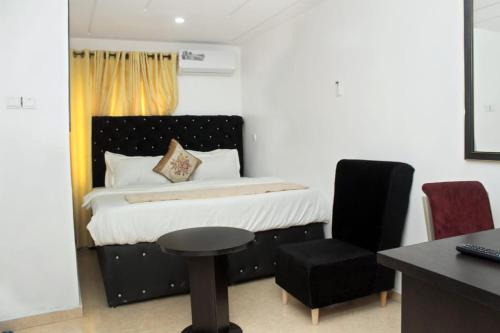 um quarto com uma cama, uma secretária e uma cadeira em Gregory University Guest House em Lagos