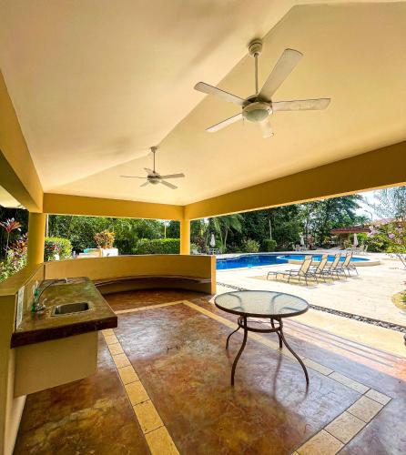a living room with a ceiling fan and a table at Dream Site near Punta Leona in Jacó