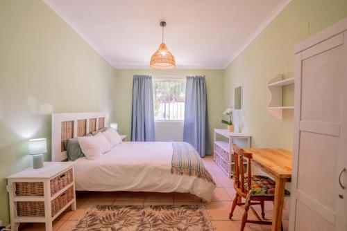 Cape Town的住宿－The Avenue House，一间卧室配有一张床、一张桌子和一张书桌