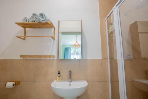 een badkamer met een witte wastafel en een douche bij The Avenue House in Kaapstad