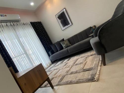 a living room with a black couch and a rug at Benteh Aqua View in Bathurst