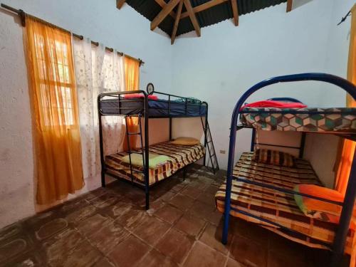 a room with two bunk beds and a window at Casa de campo amplia y tranquila in Juayúa