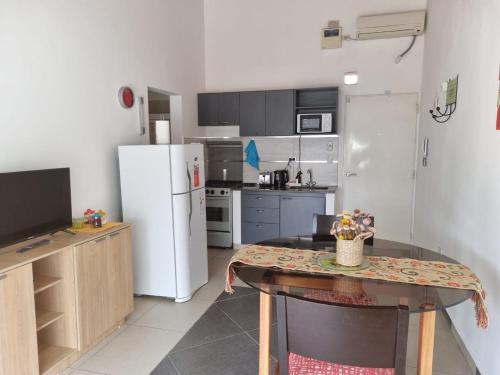 een keuken met een tafel en een witte koelkast bij Departamento Las Calandrias in Cipolletti