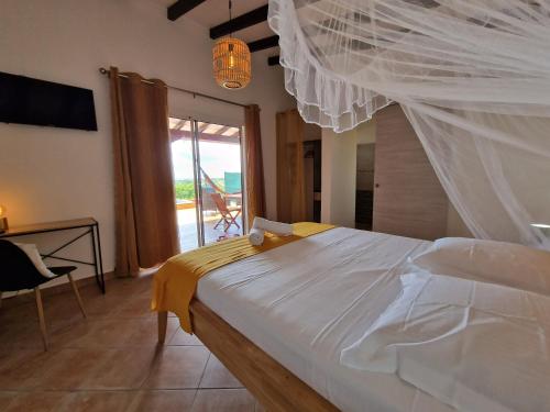 1 dormitorio con 1 cama con dosel blanco en Le Jeïpur Villa vue mer piscine privée, en Saint-François
