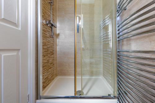 a shower with a glass door in a bathroom at Tranquil Six Bedroom Haven in Northampton