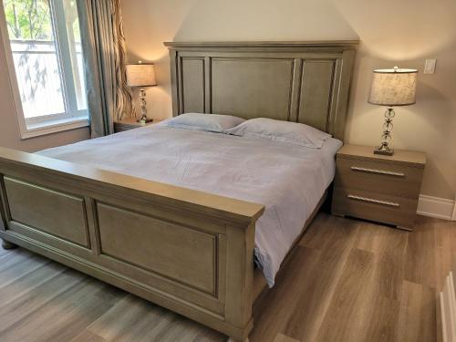 a large bed with a wooden headboard in a bedroom at Jackzhang in Aurora